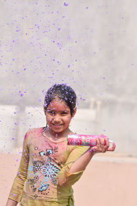 Portrait of girl playing during holi