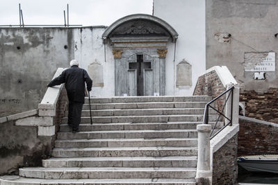 Rear view of senior man on steps at church