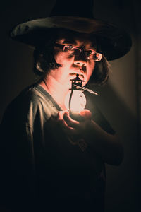 Portrait of young woman holding hat