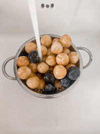 A close-up of plums washed in a sink