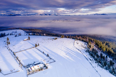 Scenic view of snow covered landscape against sky during sunset