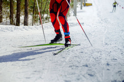 Low section of person skiing on snow covered field