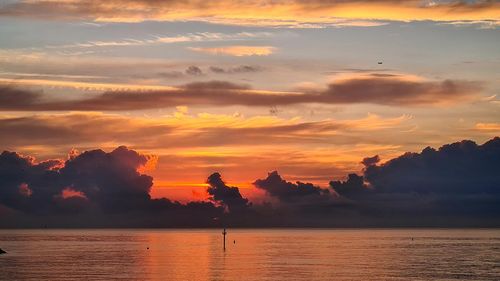 Scenic view of sea against romantic sky at sunset