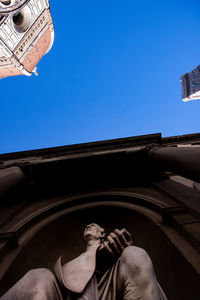 Low angle view of man against building against clear sky