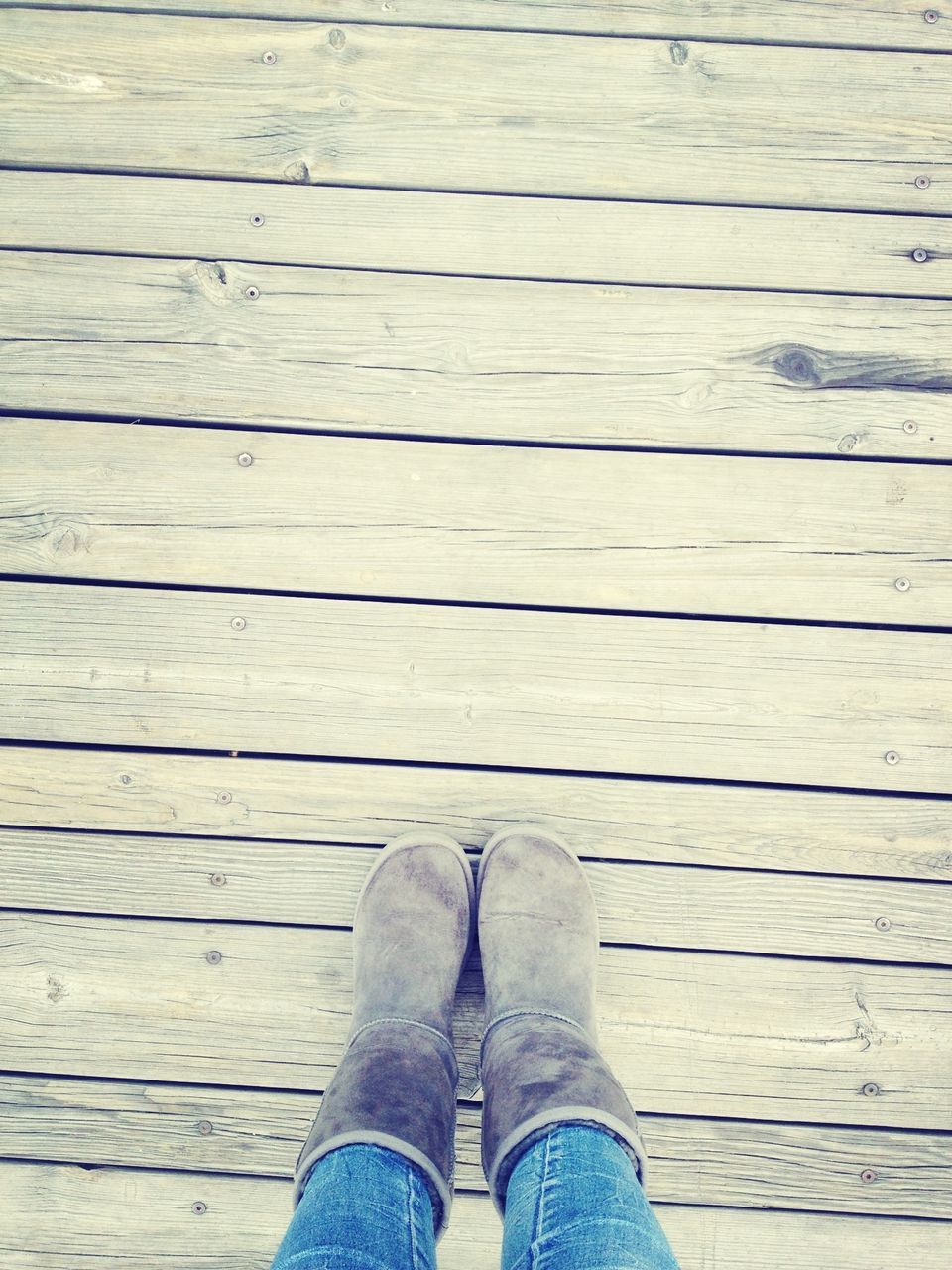 wood - material, wooden, plank, wood, one person, shoe, low section, boardwalk, part of, close-up, high angle view, person, personal perspective, textured, brown, standing, pier, outdoors, hardwood floor