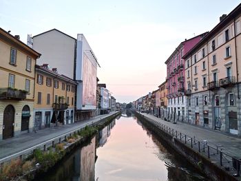 Canal amidst buildings against sky