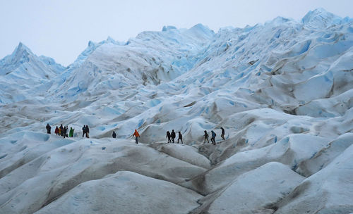 People walking on glacier during winter