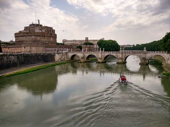 Boat moving on lake against bridge and historic building