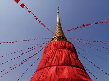 Low angle view of red flags hanging against building