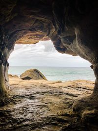 Scenic view of sea against sky seen through cave