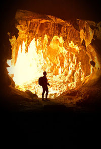 Silhouette woman standing in cave