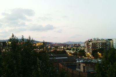 Buildings in town against cloudy sky