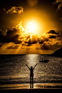 Silhouette man standing by sea against sky during sunset