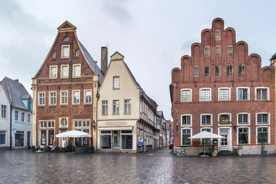 Buildings by canal against sky