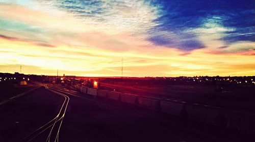 View of illuminated street lights at sunset