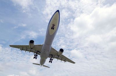 Low angle view of airplane flying against sky