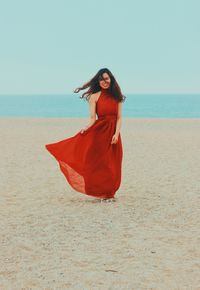 Woman with sunglasses on beach against sky