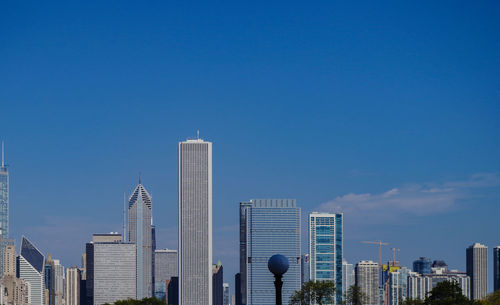 Modern buildings in city against blue sky