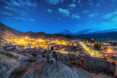 High angle view of illuminated cityscape against sky at night