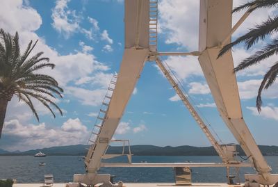 Low angle view of harbour crane against sky