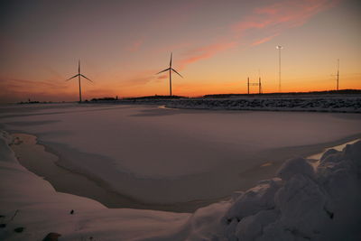 Scenic view of snow covered landscape against sky during sunset