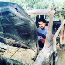 High angle view of man in abandoned car