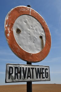 Close-up of road sign against sky