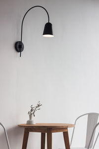 Electric lamp hanging on table against wall at home