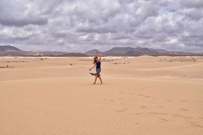 Woman standing on sand dune in desert