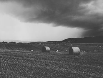 Hay bales on field against sky