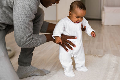 Rear view of mother and daughter on floor