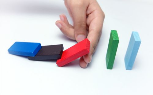 Close-up of hand holding toy over white background