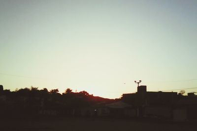 Silhouette houses against clear sky