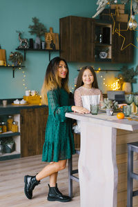 Mom's idle serving of the table for dinner, her daughter helps her in the kitchen