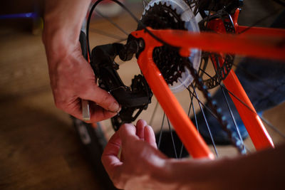 Hand of a man with a multitool near the wheel and brakes of the bike. bike repair, setting up disc 