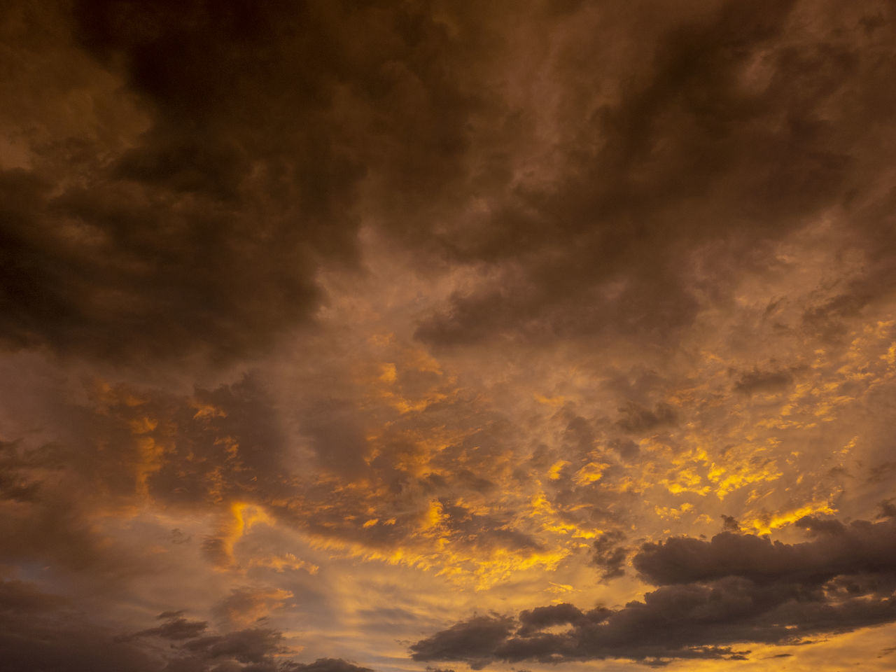 LOW ANGLE VIEW OF STORM CLOUDS AT SUNSET