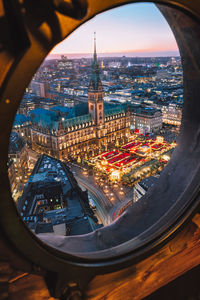 High angle view of buildings in city seen through glass window