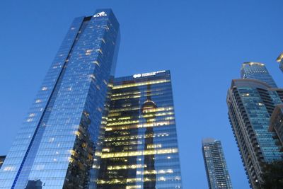 Low angle view of skyscrapers against clear blue sky