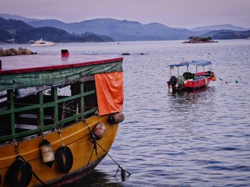 Fishing boat moored in sea against sky