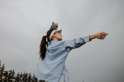 Side view of woman standing against sky