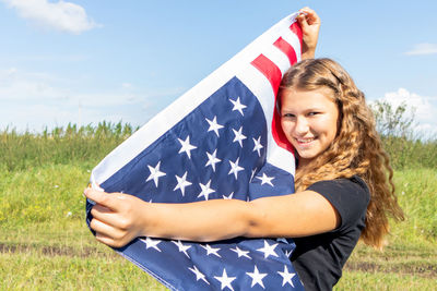 Portrait of smiling young woman lying on field