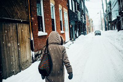 Rear view of woman walking in snow