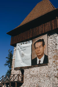 Low angle view of man on building against sky