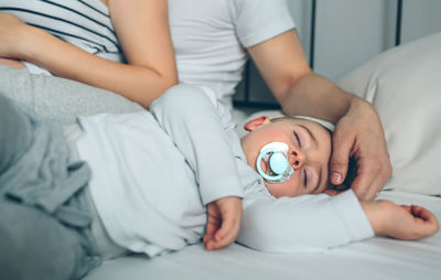 Pregnant woman with husband and son on bed at home