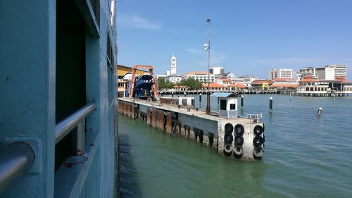 View of boats in canal by buildings in city