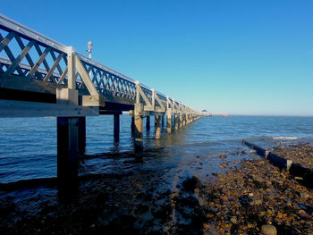 Pier over sea against clear sky