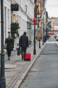 Rear view of people walking on city street