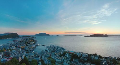 High angle view of townscape by sea against sky