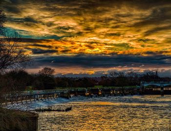 Scenic view of lake against dramatic sky