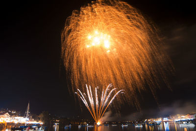 Firework display over river at night